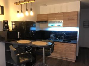 a kitchen with a black refrigerator and a table with chairs at Villa Napoléon in Pierrefonds +5 photos