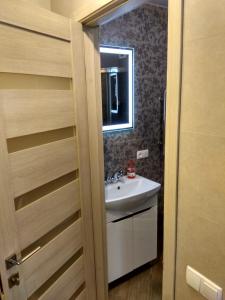 a bathroom with a sink and a mirror at Luxury Loft в центре Полтавы in Poltava