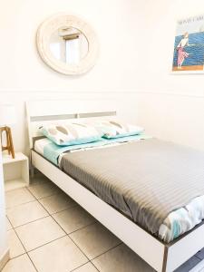 ニースにあるPortobello residenceの白いベッドルーム(ベッド1台、鏡付)