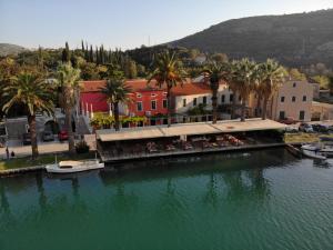 a large body of water with buildings and palm trees at Hotel Vimbula - Komolac in Mokošica