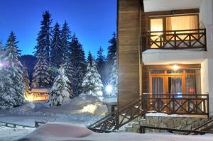 a house in the snow at night at Family Apartment "Cosy Nature" in Smolyan