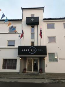 un hotel con bandiere di fronte a un edificio di Arctic Hotel Nordkapp a Honningsvåg