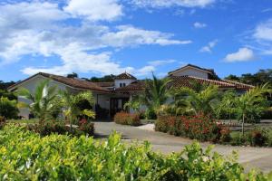 a house with a garden in front of it at Pura Vida House in Tamarindo