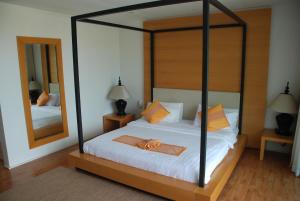 a bedroom with a canopy bed with a mirror at The Park Samui in Choeng Mon Beach
