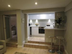 a kitchen with a stairway leading to a living room at The Apartment, Lower Ground Floor, Clarendon Place in Leamington Spa