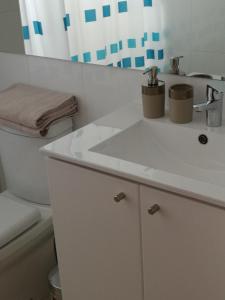 a bathroom with a white sink and a toilet at Excelente departamento en Las Condes in Santiago