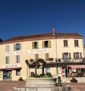 a large white building with a sign on it at Gites Le Lancelot in Ambierle