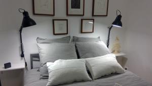 ヴァンスにあるLa MoMAのベッド(白い枕、壁にランプ2つ付)