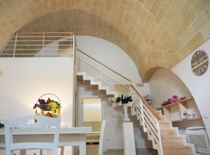 a room with a spiral staircase and a white table and chairs at L'ALBERO DELLA VITA in Matera