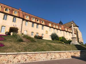 a large brick building with a lawn in front of it at Gites Le Lancelot in Ambierle