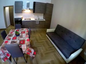 ein Wohnzimmer mit einem Tisch und einem Sofa sowie eine Küche in der Unterkunft Welcome Home Apt. 2 in Pozzallo