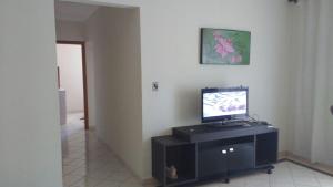 a living room with a television on a cabinet at APARTAMENTO MAX 7 in Praia Grande