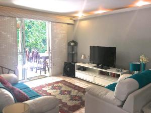 a living room with a couch and a flat screen tv at Casa Riviera de São Lourenço in Riviera de São Lourenço