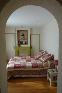 um quarto com uma cama com um cobertor colorido em La Ferme De Tigny em Tigny-Noyelle