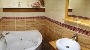 a bathroom with a tub and a sink at La Ferme De Tigny in Tigny-Noyelle