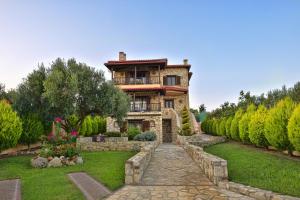 a stone house with a garden in front of it at Captain's Villa Appartments in Psakoudia