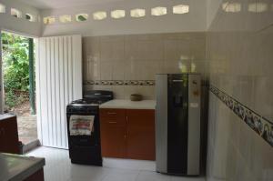 a kitchen with a stove and a refrigerator at Casa Oasis de colibri in El Zaino