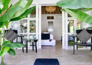 White Palm Hotel Bali في جيمباران: غرفة معيشة مع طاولة وكراسي زجاجية