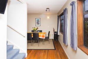 a dining room with a table and chairs at DOLLY KIWI ICONIC BACH IN PRIME LOCATION in New Plymouth