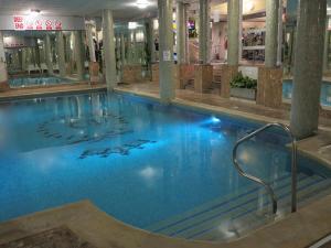 a large swimming pool with blue water in a building at Queens Hotel & Spa in Brighton & Hove