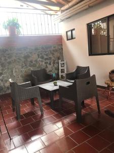 Habitación con mesa, sillas y pared de piedra. en Hostal Rous San Gil, en San Gil