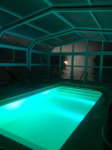 a swimming pool with blue lighting in a room at Refugio De Mar in Valeria del Mar
