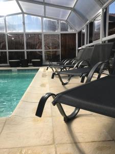 a row of empty chairs next to a swimming pool at Refugio De Mar in Valeria del Mar