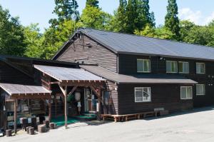 un gran edificio de madera con techo de gambrel en Yachi Onsen en Towada