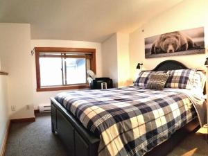 a bedroom with a bed with a checkered blanket at Downtown Loft, Mountain Views, Fireplace, Couple's Retreat, Walker's Paradise in Canmore