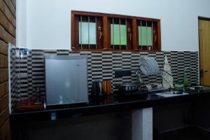 a kitchen with a counter with a sink and a microwave at Talalla 170 Villa in Talalla South