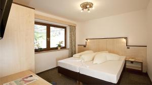a bedroom with a large white bed with a window at Appartement Alpin in Sölden