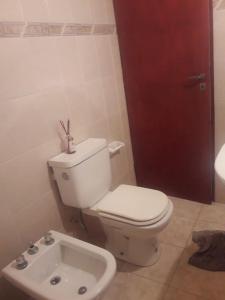 a bathroom with a white toilet and a sink at 994 Tucumán in San Fernando del Valle de Catamarca