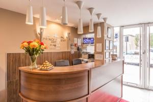 un ristorante con bancone e fiori di Prince Regent Hotel Excel London a Londra