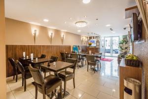 una sala da pranzo con tavoli e sedie in un ristorante di Prince Regent Hotel Excel London a Londra