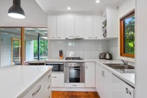 
a kitchen with white cabinets and white appliances at Ultimate Ultimo in Mansfield
