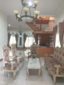 sala de estar con 2 sillas y mesa en Rumah Puan Homestay, en Bandar Lampung