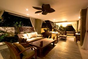 a living room with a couch and a ceiling fan at Villa Teresa in Canggu