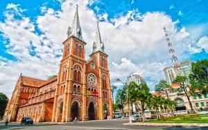 an old building with a clock tower in a city at Nouveau Happy Inn - Bến Thành in Ho Chi Minh City