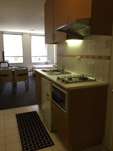 a kitchen with a stove top oven next to a table at Flinders Street 238, CLEMENTS HOUSE at Federation Square, Melbourne, Australia in Melbourne