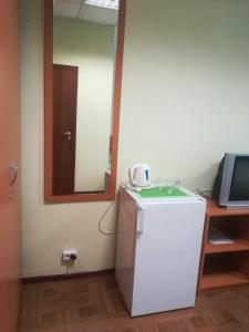 a small refrigerator in a room with a mirror at Ariel гостиница in Ivanovo