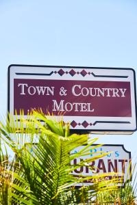 un letrero de calle para un motel de pueblo y campo en Town and Country Motel, en Sídney