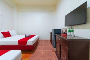 a hotel room with a bed and a flat screen tv at RedDoorz near Walking Street Angeles City in Angeles
