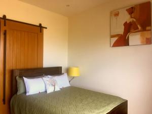 a bedroom with a bed and a painting on the wall at The Cliffs Seaside Lodge in Tuatapere
