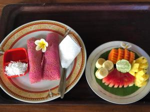 a tray with two plates of food and a knife at Depa House in Ubud