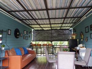 a living room with a couch and a table at Baan JaoKorKluay บ้านเจ้ากอกล้วย in Chiang Rai