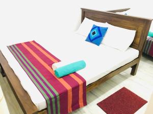 - une chambre avec un lit et une couverture colorée dans l'établissement Lakeside Villa, à Anurâdhapura