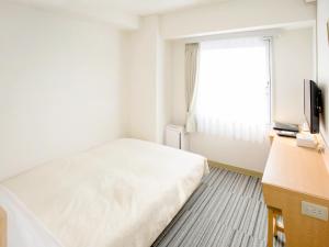 1 dormitorio con 1 cama, TV y ventana en Premier Hotel Cabin Matsumoto, en Matsumoto