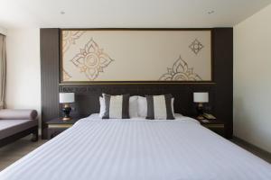 a bedroom with a large white bed with two lamps at Krabi Heritage Hotel - SHA Extra Plus in Ao Nang Beach