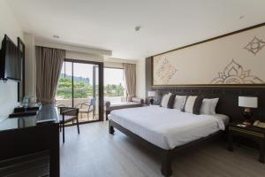 a hotel room with a bed and a balcony at Krabi Heritage Hotel in Ao Nang Beach