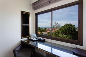 a bathroom with a large window with a view at Krabi Heritage Hotel - SHA Extra Plus in Ao Nang Beach